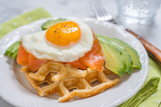 Gezond eten ontbijt havermout wafels, gerookte zalm, avocado en ei