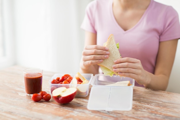 gezond eten, opslag, diëten en mensen concept - close-up van vrouw met voedsel in plastic container thuis keuken