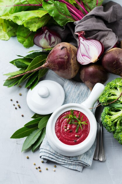 Gezond eten, schoon eten concept. Seizoensgebonden herfst herfst groenten romige bietensoep met ingrediënten op een keukentafel. Bovenaanzicht plat lag achtergrond