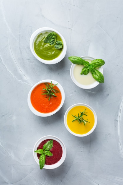 Gezond eten, schoon eten concept. Verscheidenheid aan kleurrijke seizoensgebonden herfstgroenten romige soepen met ingrediënten. Pompoen, broccoli, wortel, rode biet, aardappel, tomatenspinazie. plat leggen
