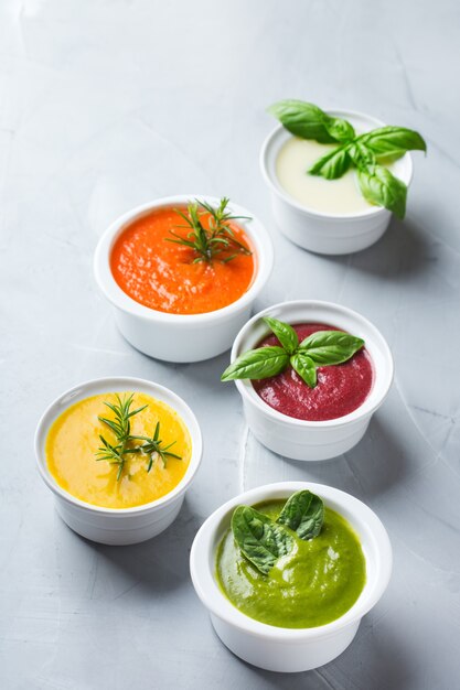 Gezond eten, schoon eten concept. Verscheidenheid aan kleurrijke seizoensgebonden herfstgroenten romige soepen met ingrediënten. Pompoen, broccoli, wortel, rode biet, aardappel, tomatenspinazie