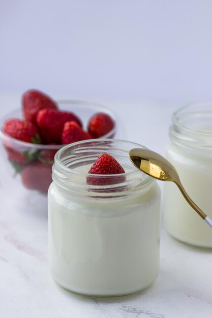 Gezond eten thuis Zelfgemaakte yoghurt met aardbeien in glazen potten