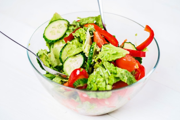 Gezond eten, vegetarisch eten, diëten en mensen concept - close-up groentesalade met olijfolie op een witte achtergrond