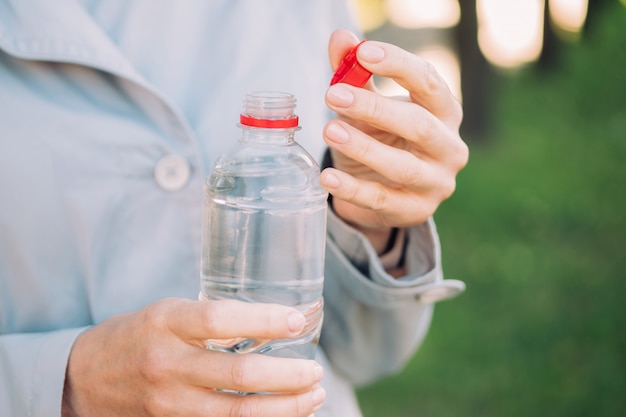 Gezond levensstijlconcept - het meisje houdt een plastic fles water.