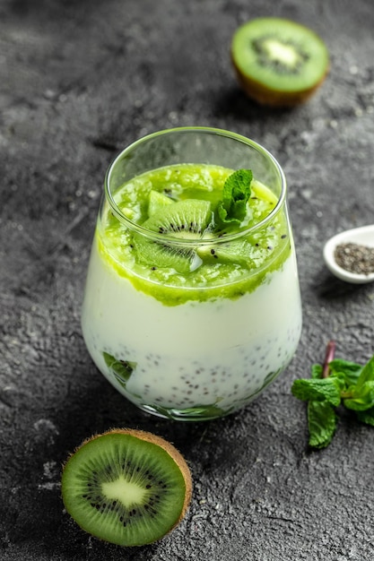 Gezond ontbijt chia pudding met kiwi in glazen potten op een witte tafel Schoon eten dieet veganistisch voedsel concept verticaal beeld