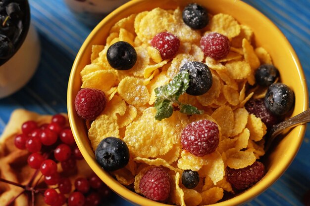 Gezond ontbijt Cornflakes met frambozen en bosbessengranola met yoghurt en bessenwafeltjes en melk