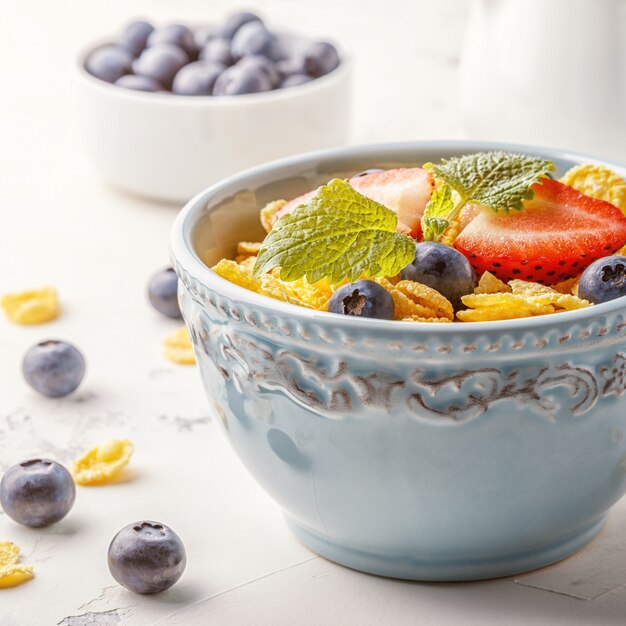 Gezond ontbijt - cornflakes met fruit en bessen.