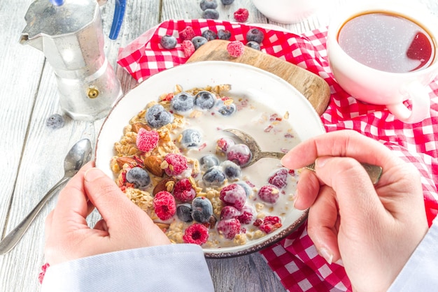 Gezond ontbijt eten Close-up video van het eten van granola cornflakes met melk, verse bes en noten