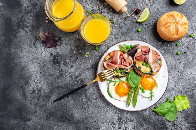 Gezond ontbijt. gegrild broodje met spinazie en kaas, asperges, jamon, ham, prosciutto en ei