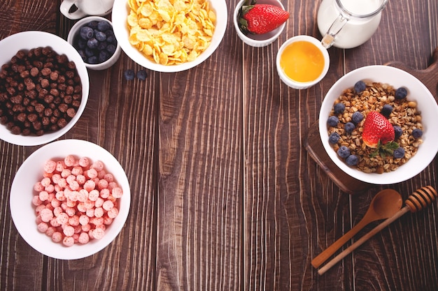 Gezond ontbijt. Granola, muesli met verse bessen en andere vlokken en maïsbolletjes aan de oppervlakte. Bovenaanzicht