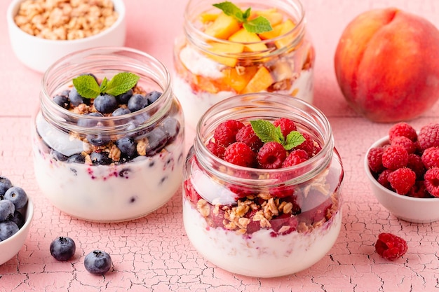 Gezond ontbijt Granola muesli, yoghurt en fruit geserveerd in glazen potten