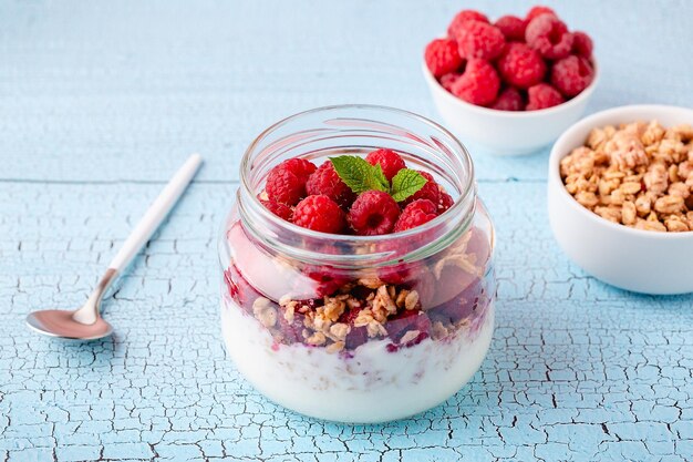 Gezond ontbijt Granola muesli, yoghurt en fruit geserveerd in glazen potten
