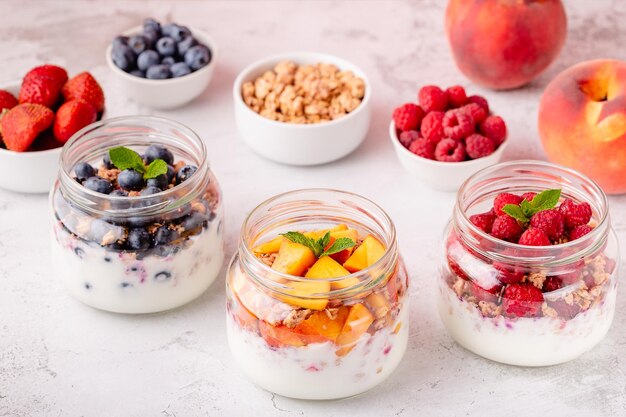 Gezond ontbijt Granola muesli, yoghurt en fruit geserveerd in glazen potten