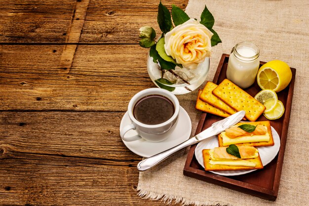 Gezond ontbijt. Kopje koffie (zwarte thee), melk, crackers met boter en zalm