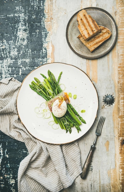 Gezond ontbijt met groene asperges, zachtgekookt ei, bacon en toast