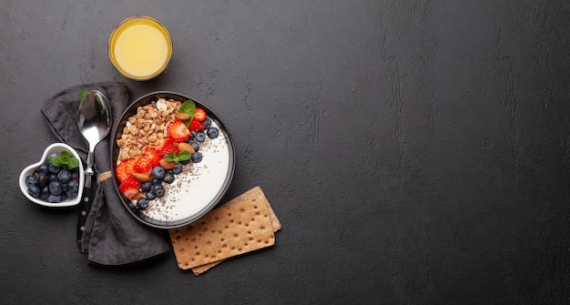 Gezond ontbijt met kom granola-yoghurt en verse bessen