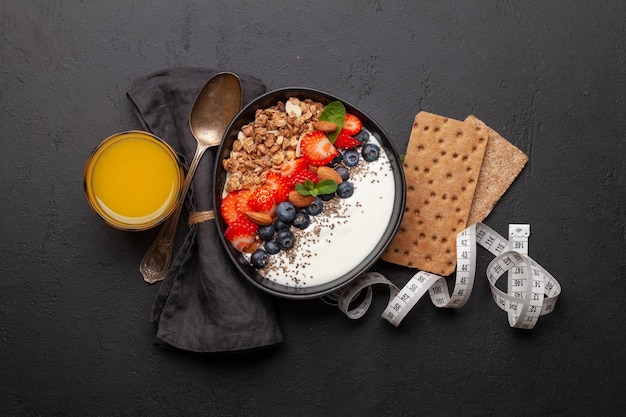 Gezond ontbijt met kom granola-yoghurt en verse bessen