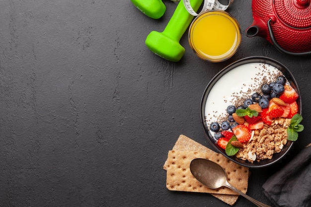 Foto gezond ontbijt met kom granola-yoghurt en verse bessen