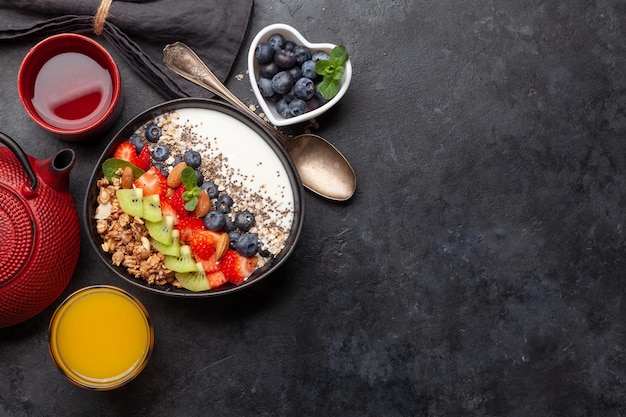 Gezond ontbijt met kom granola-yoghurt en verse bessen