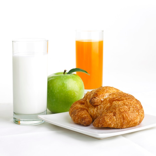 Foto gezond ontbijt met melk, sinaasappel en appel geïsoleerd op wit