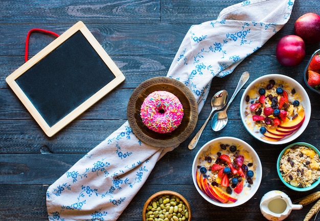 Gezond ontbijt met milkmuesli en fruit op een houten achtergrond.