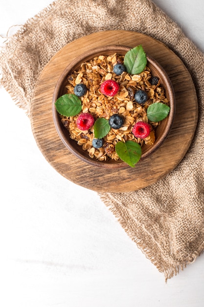 Gezond ontbijt met muesli en bessen op witte achtergrond