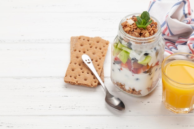 Gezond ontbijt met potje granola yoghurt en verse bessen
