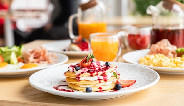 Gezond ontbijt met thee havermoutpap kwark beignets pannenkoeken roerei en gebakken ei