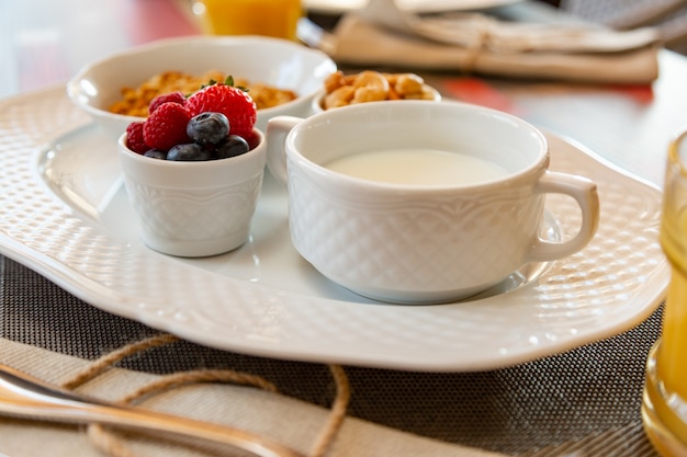 Gezond ontbijt met vers sap en muesli met melk en bessen