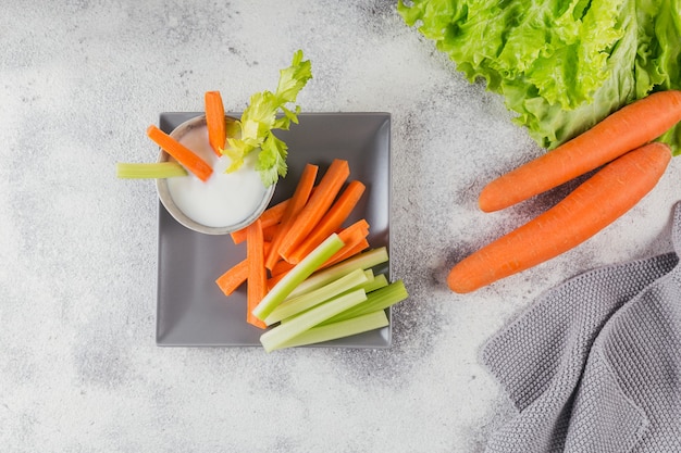 Gezond ontbijt met yoghurt, selderij en worteltjes. Dieet en gezonde snacks.