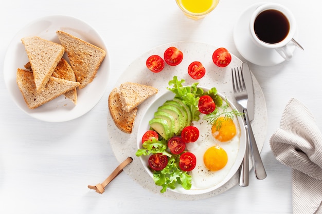 Gezond ontbijt plat lag. gebakken eieren, avocado, tomaat, toast