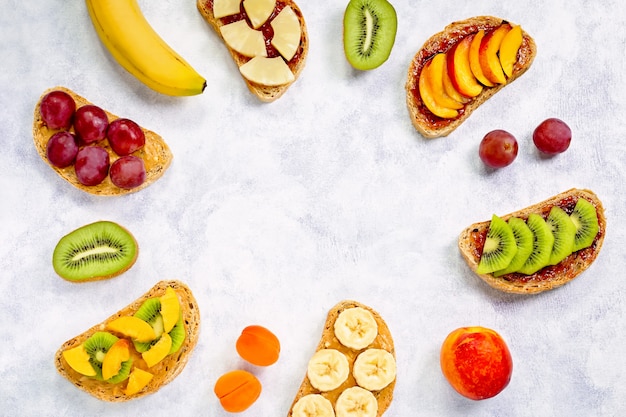 Gezond ontbijt toast met pindakaas, aardbeienjam, fruit