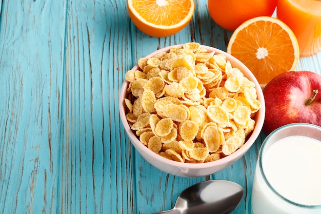 Gezond ontbijt van cornflakes en fruit op een blauwe houten achtergrond. Plaats voor tekst. Bovenaanzicht.