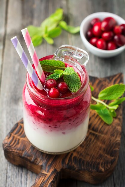 Gezond ontbijt. Verse cranberry smoothie in een glazen pot op het oude houten oppervlak. Selectieve aandacht.