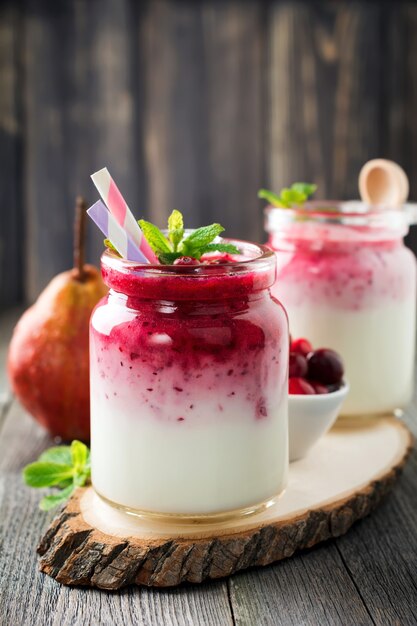 Gezond ontbijt. Verse cranberry smoothie in een glazen pot op het oude houten oppervlak. Selectieve aandacht.