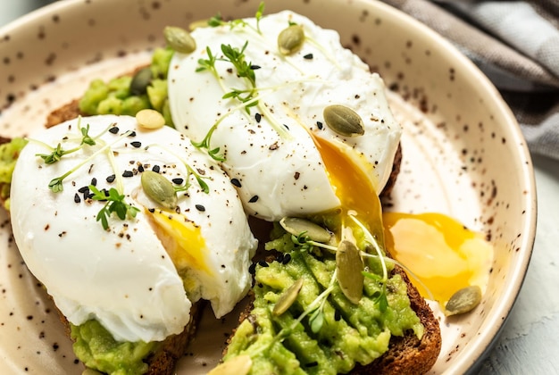 Gezond ontbijt volkoren geroosterd brood met avocado en gepocheerd ei Ontbijt met vegetarisch voedsel gezond dieet concept