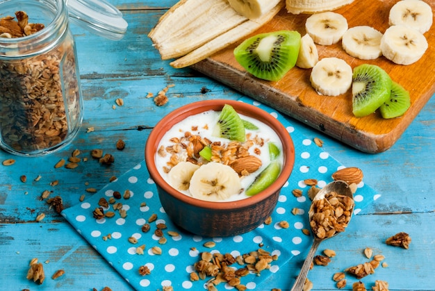 Gezond ontbijt: yoghurt met granola, banaan en kiwi