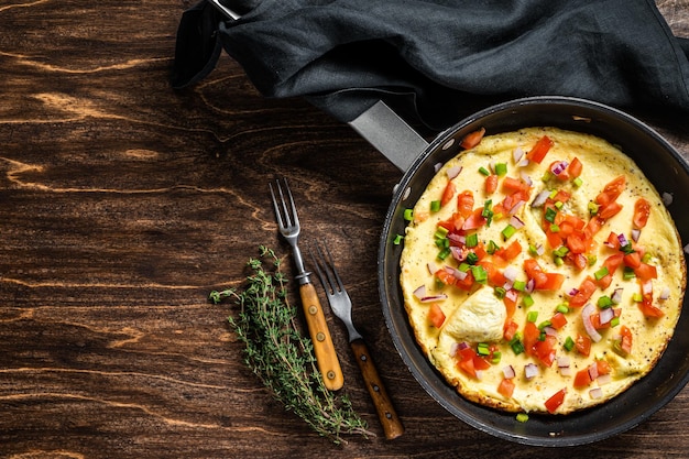 Gezond ontbijtvoedsel, Gevulde eiomelet met groenten in een skelet. Houten achtergrond. Bovenaanzicht. Ruimte kopiëren.