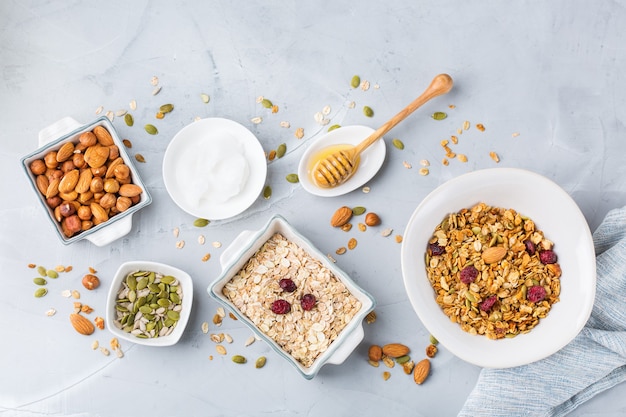 Gezond schoon eten, diëten en voeding, fitness, evenwichtige voeding, ontbijtconcept. Zelfgemaakte muesli muesli met ingrediënten op een tafel. Bovenaanzicht plat lag achtergrond