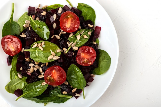 Gezond vegetarisch eten. Salade met rode biet, spinazie, cherry tomaten en zaden.