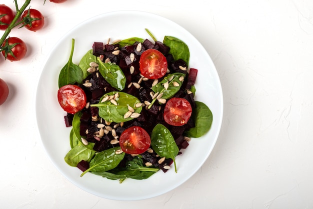 Gezond vegetarisch eten. Salade met rode biet, spinazie, cherry tomaten en zaden.