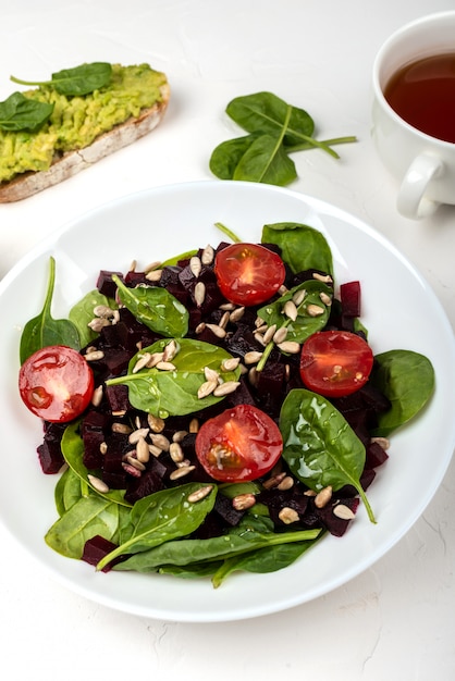 Gezond vegetarisch eten. salade met rode biet, spinazie, cherry tomaten en zaden.