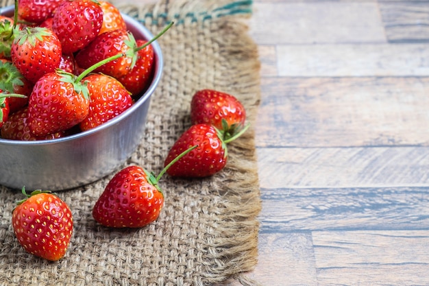 Gezond vers aardbeifruit in een kom op een houten lijst