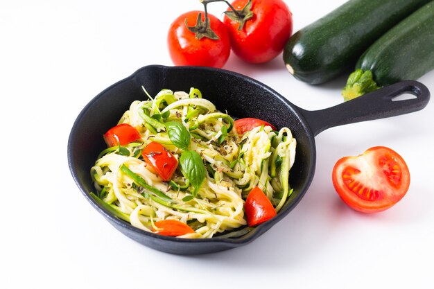 Gezond voedsel concept zelfgemaakte Guilten-Free Courgette noedels, pasta met tomaat in ijzer koekepan pan