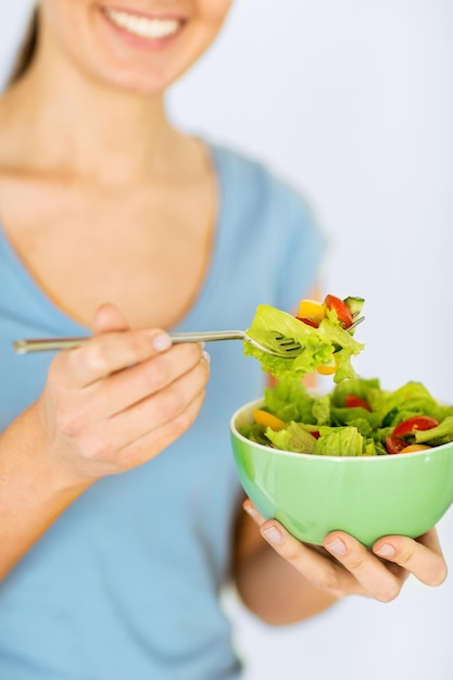 gezond voedsel en keukenconcept - vrouw die salade met groenten eet