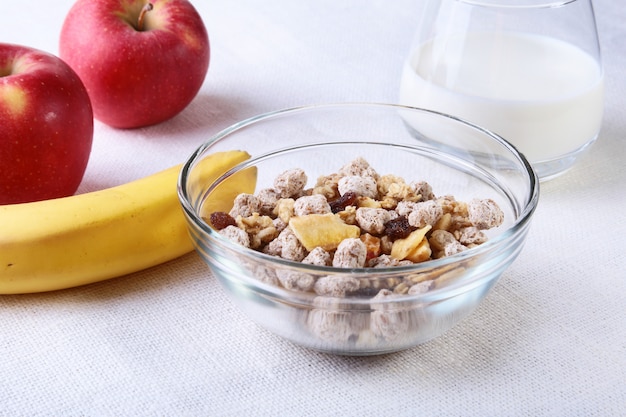 Gezond voedsel met Corn Flakes-graangewas in een kom, een appel, een banaan en een glas met melk. Ontbijt.