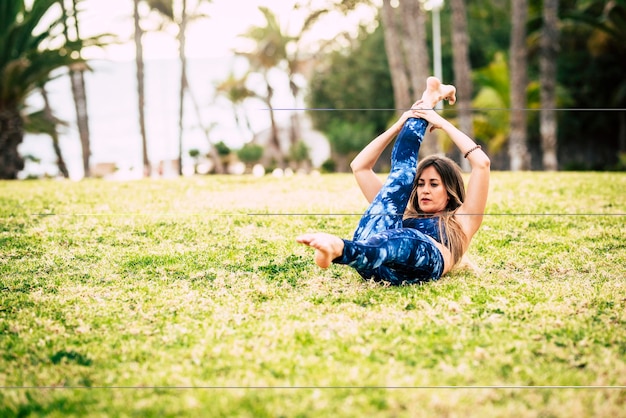 Gezonde actieve jonge vrouw doet pilates oefeningen workout buiten in het park gewichtsverlies project en vrije tijd met sportactiviteit buiten fit en gezondheid levensstijl mensen concept millennial fitness