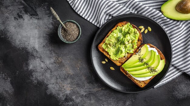 Gezonde avocadotoosts voor ontbijt of lunch met roggebrood gesneden avocado rucola pompoen en sesamzaad zout en peper Vegetarische sandwiches Plantaardig dieet Whole food concept