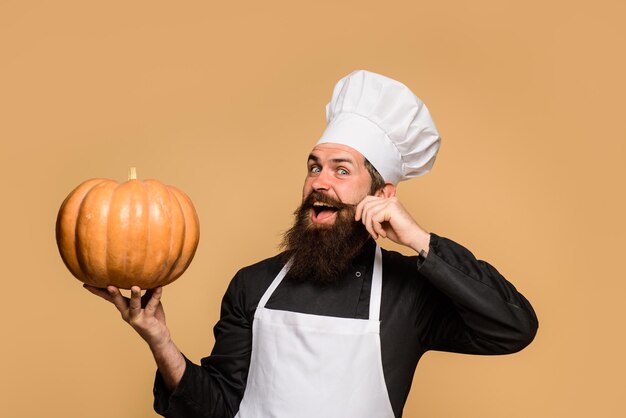 Gezonde biologische oogst groenten chef-kok man in witte schort presenteren pompoen voor culinaire herfst