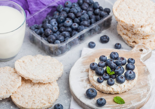 Gezonde biologische rijstwafels met ricotta en verse bosbessen en glas melk